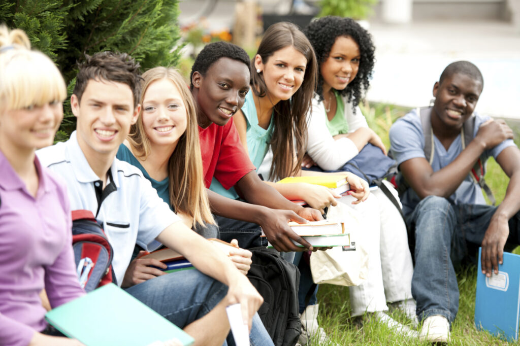 A diverse group of international students exploring a vibrant campus, surrounded by iconic landmarks of various cultures, carrying books and backpacks, engaging in discussions, with flags from different countries subtly incorporated into the background, showcasing a sense of unity and excitement in a multicultural environment.